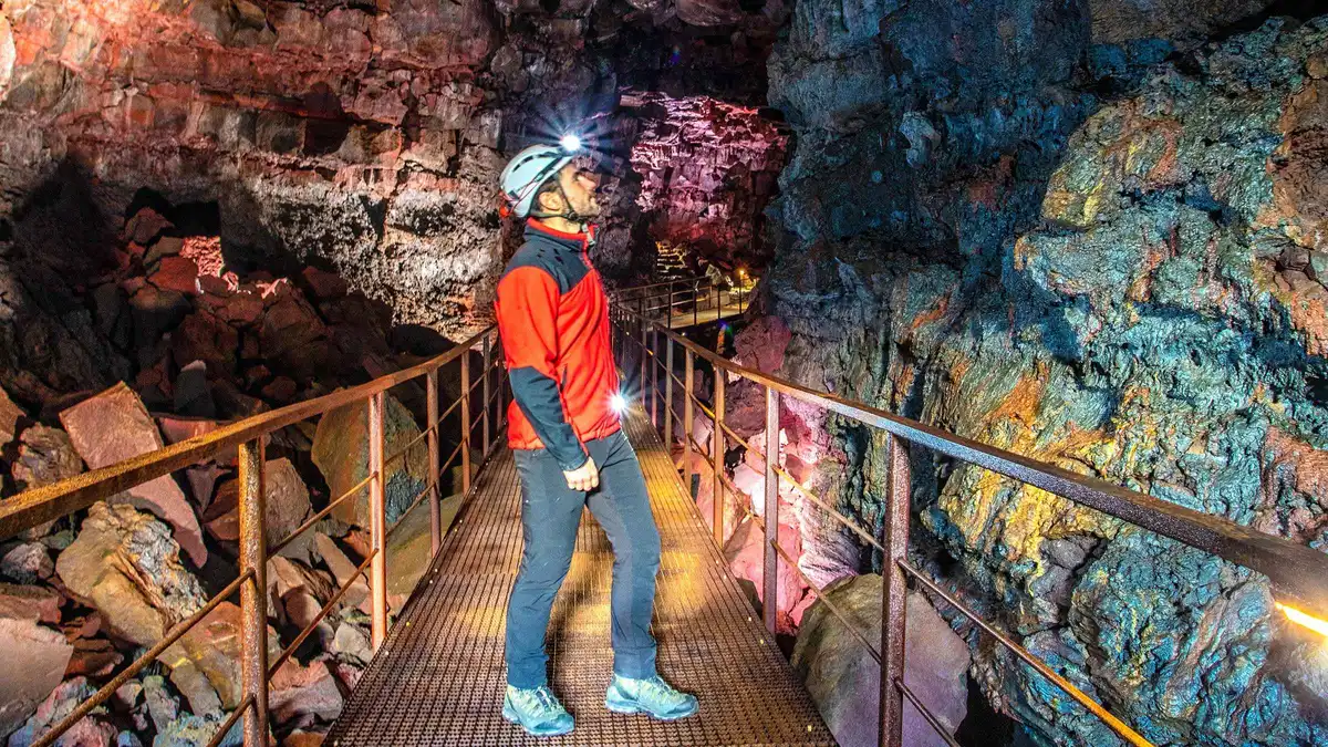 Guided group in helmets walking the lava tube on the Arctic Adventures Raufarhólshellir lava tunnel tour from Reykjavík, Iceland